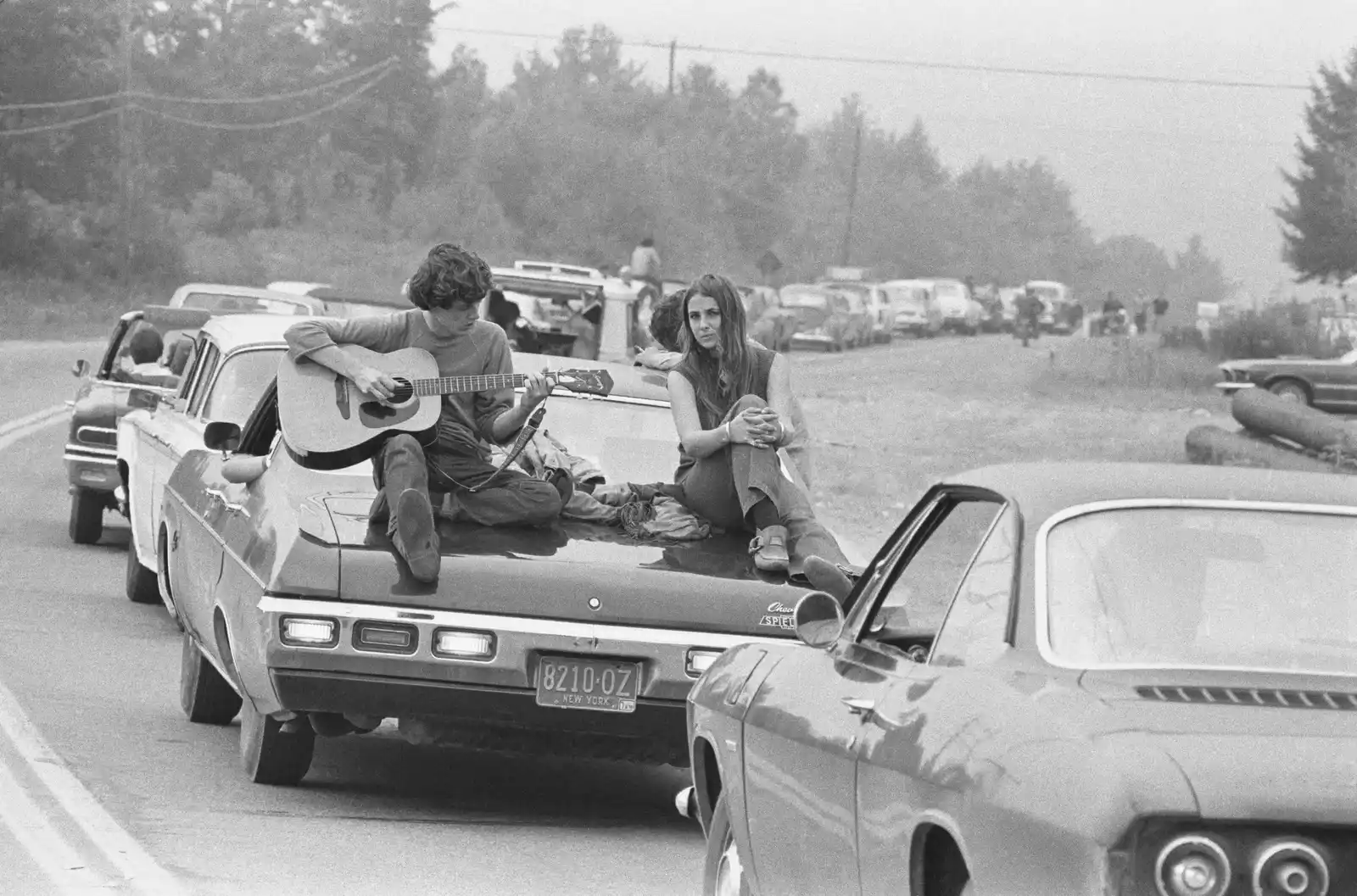 Woodstock: el paraíso hippie 3 A couple play the guitar sitting on their car on the way to the Woodstock Festival.